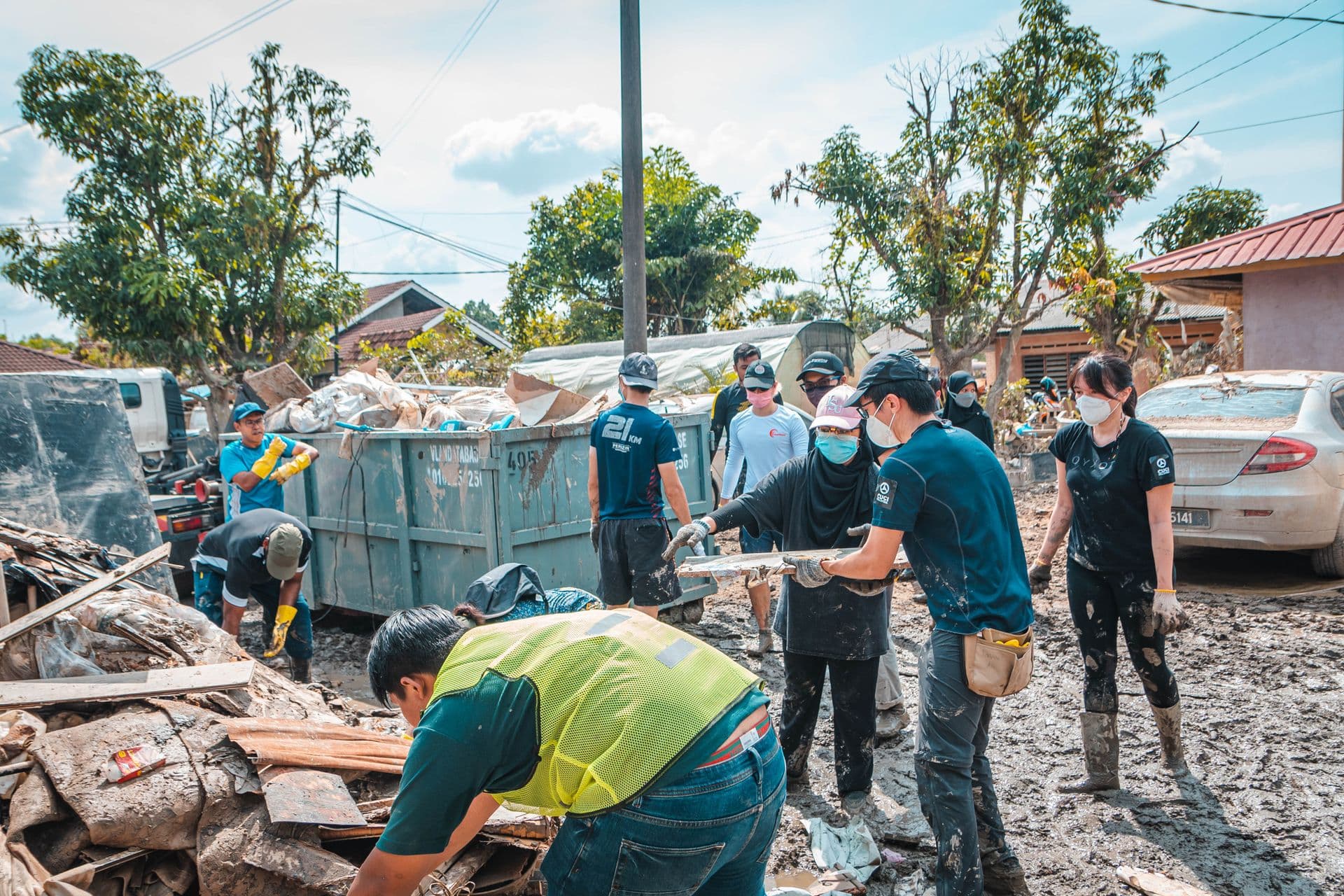 Neighborhood volunteers working side by side to clear debris from a street.