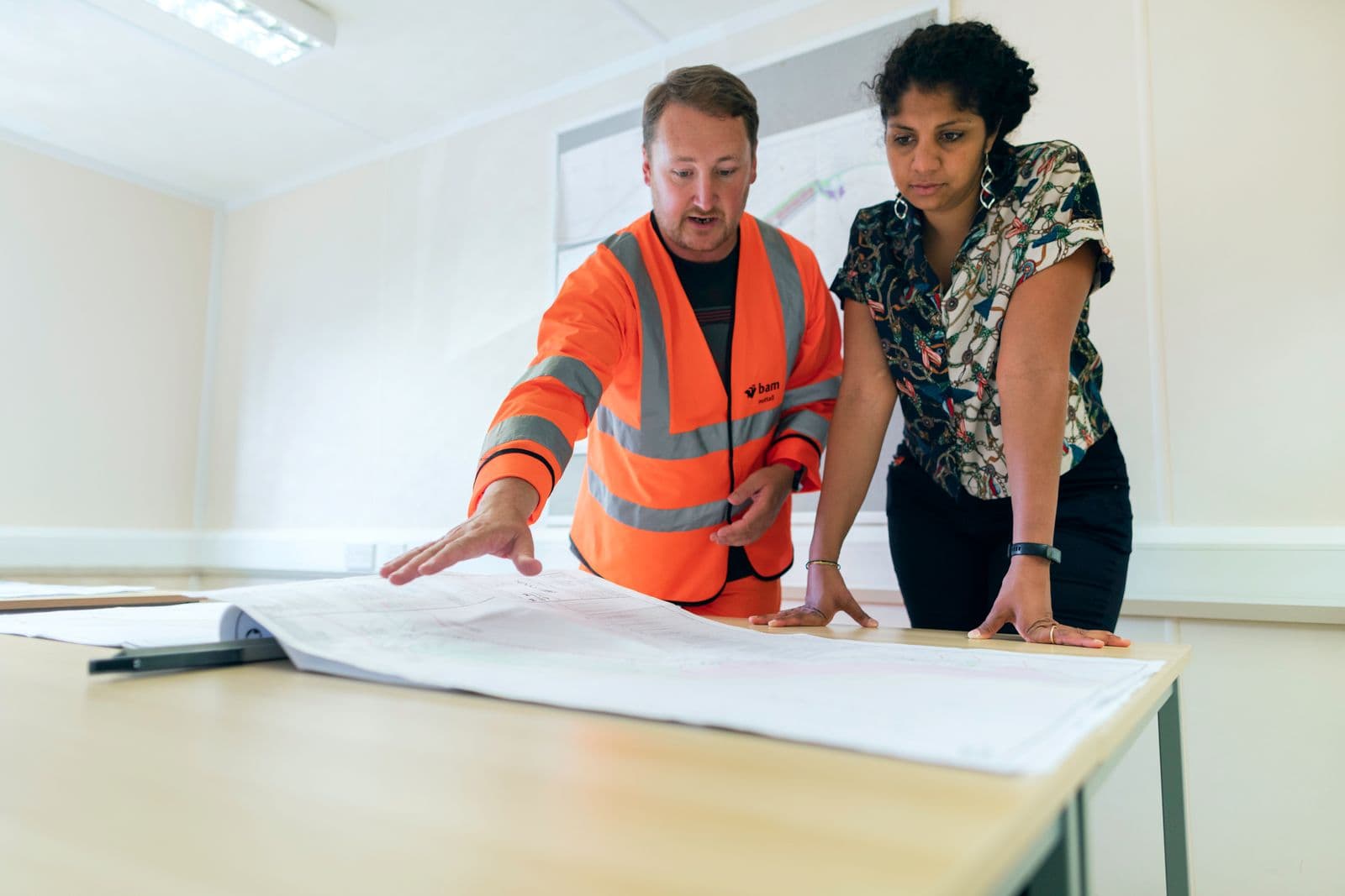 Two engineers reviewing site drawings during system design