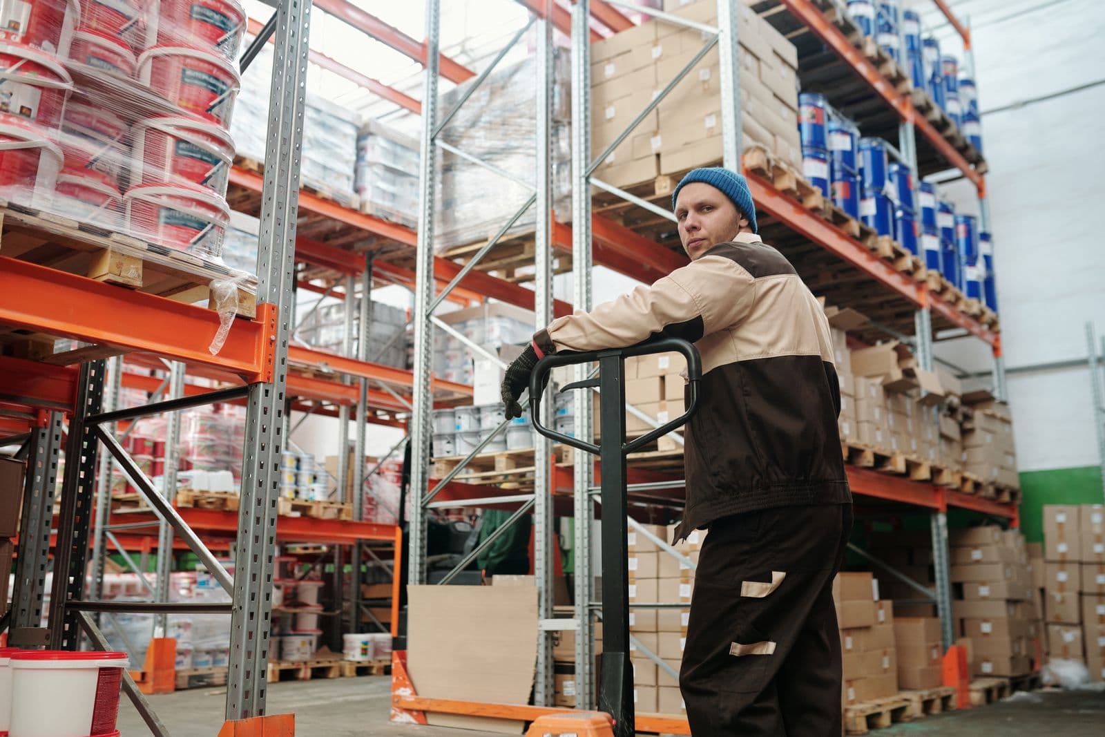 A worker staging equipment with a pallet jack while the site keeps running