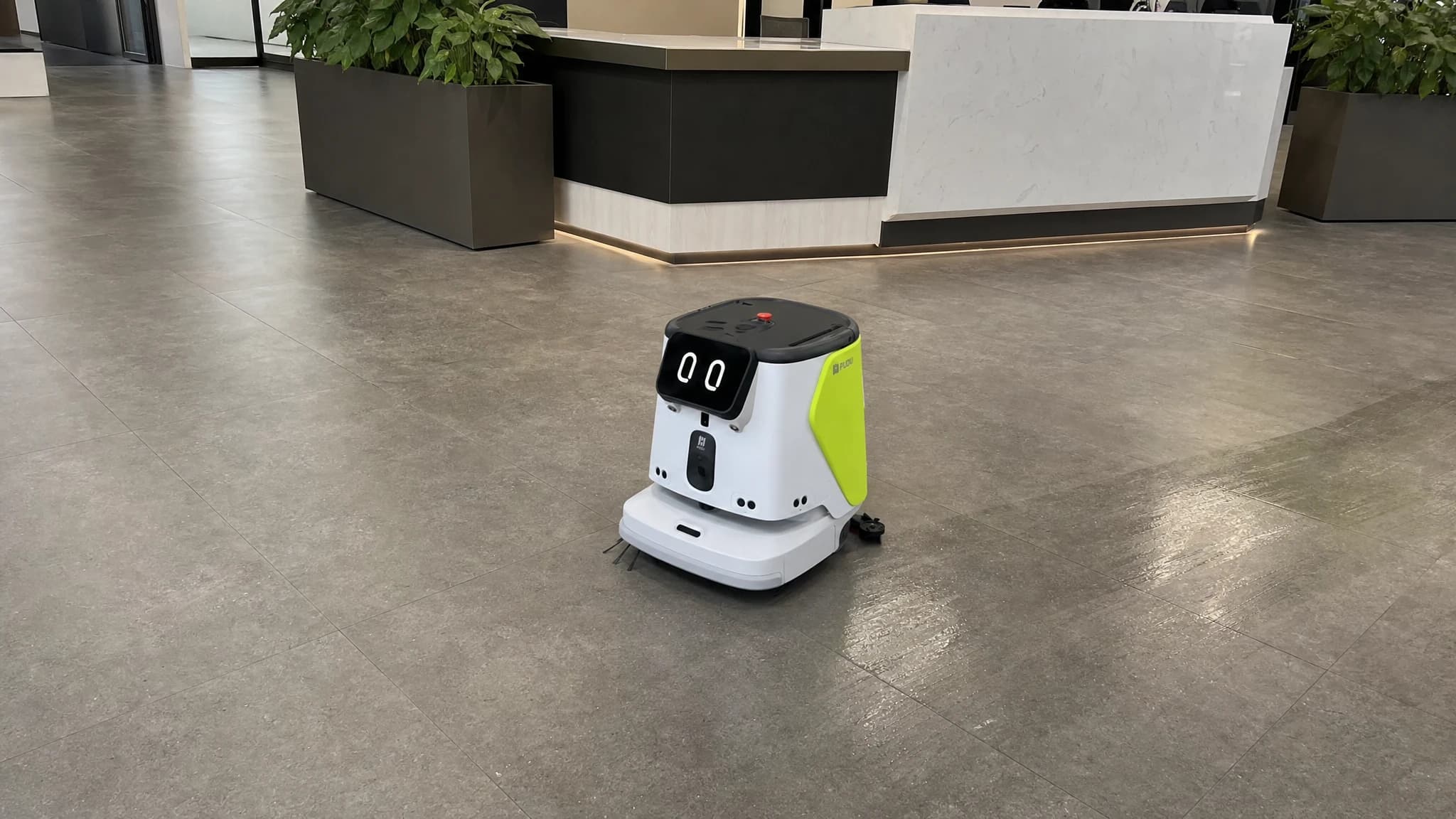 A cleaning robot working an office lobby during the day
