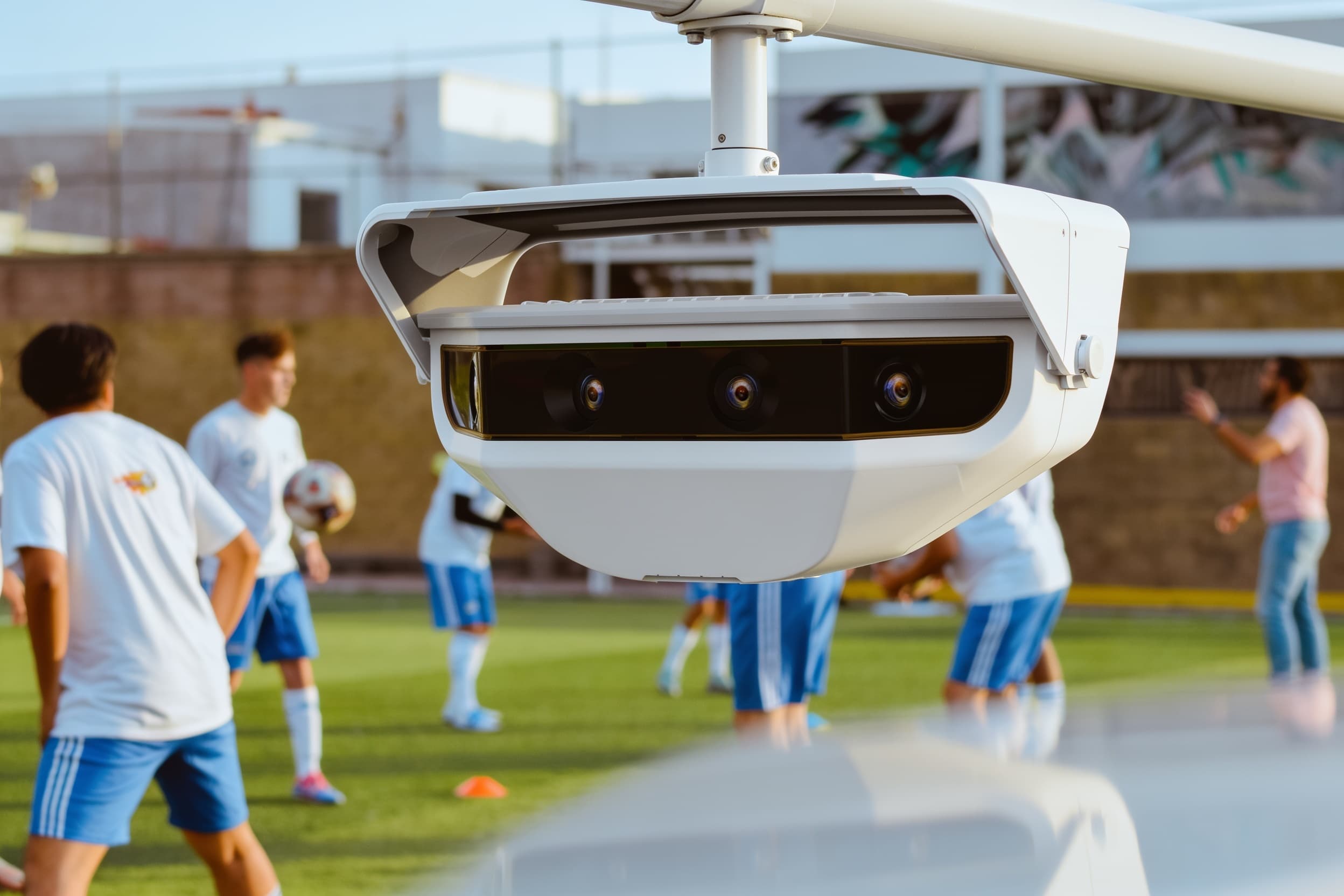 A security camera on a pole above the field