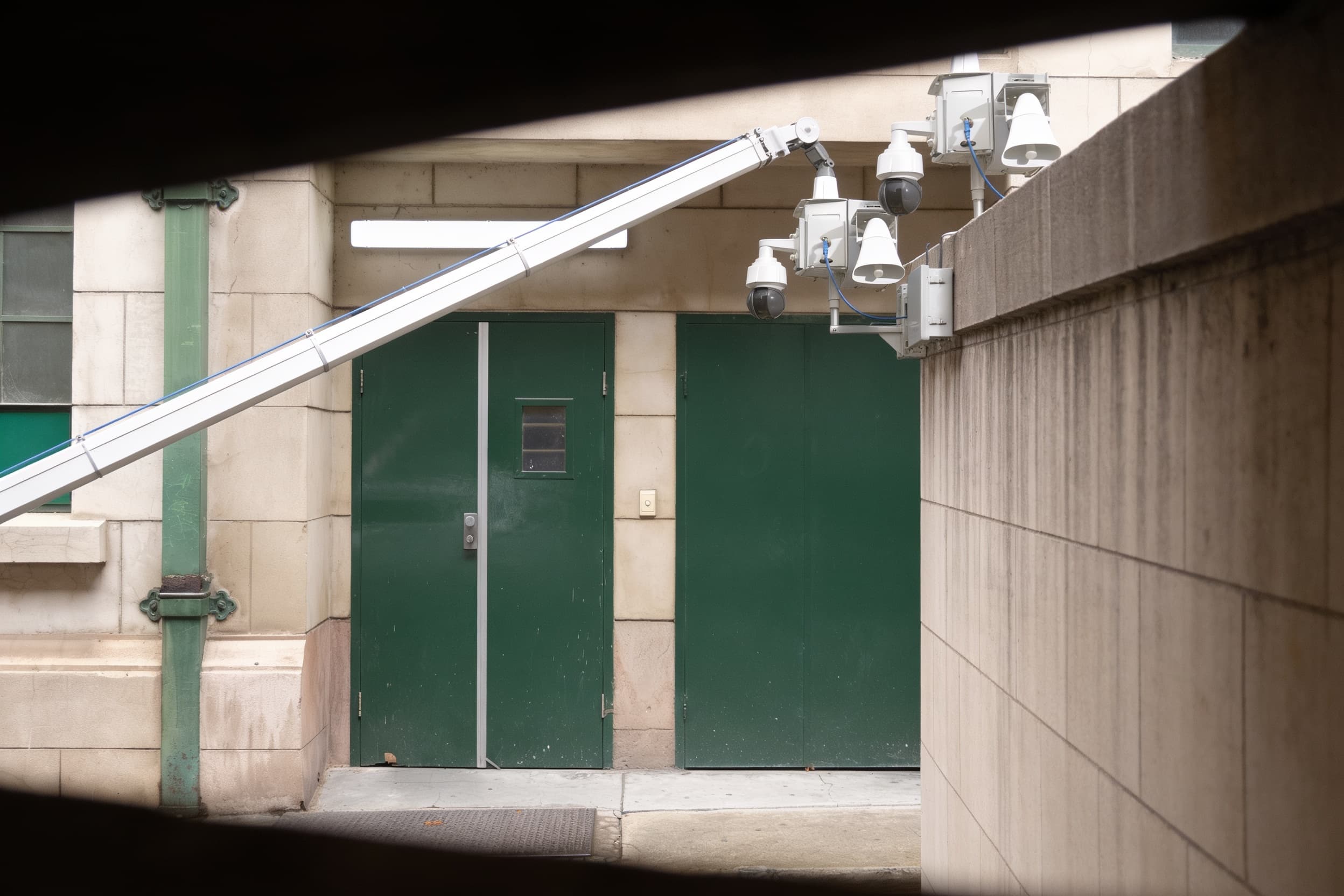 A camera on a boom arm extended over a service alley