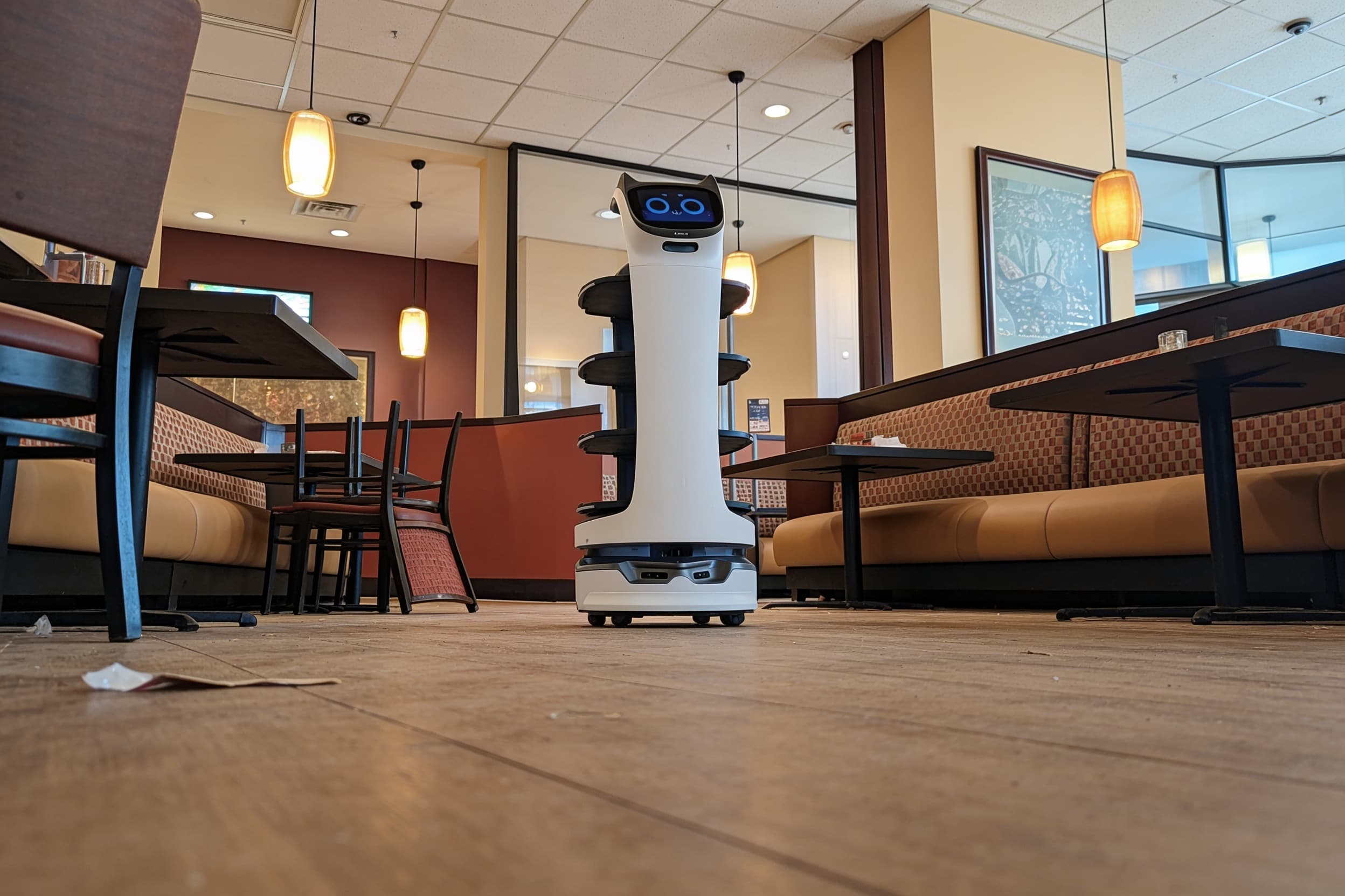 Delivery robot in an empty restaurant dining room